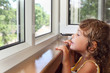 pretty smiling little girl on balcony, look from window