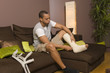 Homme assis regardant sa jambe plâtrée
