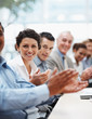 Positive business team applauding at a conference