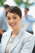 Attractive business female with colleagues at back