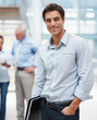 Smiling young business man with his coworker at the back