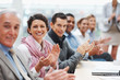 Successful business executive applauding at a conference