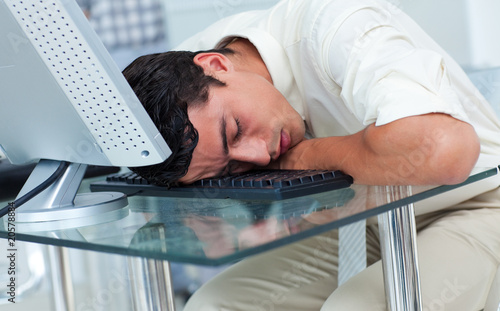 Photo: Tired businessman sleeping at his desk Tired businessman sleeping at his desk