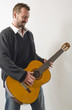 homme joue de la guitare avec émotion