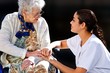 jeune soignante assistant une personne agée