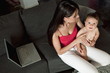 Young woman with baby and laptop computer