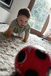 Baby boy crawling toward ball