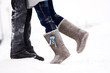 legs embracing couples standing on the snow