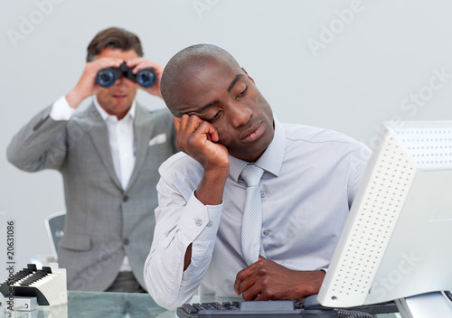 Photo: Unhappy businessman getting bored and his manager looking throug Unhappy businessman getting bored and his manager looking throug