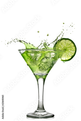 Photo: Green alcohol cocktail with splash and green lime isolated Green alcohol cocktail with splash and green lime isolated