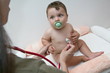 Female hand holding stethoscope to baby boy
