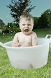 Baby boy taking bath in tub in garden