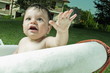 Baby boy taking bath in tub in garden