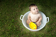 Baby boy taking bath in tub in garden