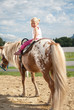 blondes mädchen beim ponyreiten
