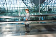 boy in  departure hall  in the Airport  on a moving staircase