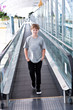 boy in the departure hall  in the  Airport on a moving staircase