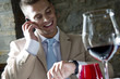 Young man in suit with mobile phone at a restaurant checking time