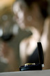 Closeup of ring with young woman in the background drinking red wine