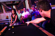 Young adults at a nightclub playing pool