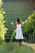 Young woman in vineyard holding wine glass