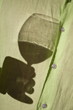 Young man's torso with shadow of hand holding wine glass