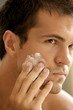 Close-up of young man applying shaving cream
