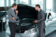 Car salesperson explaining about car's engine to customer
