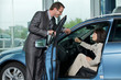 Car salesperson explaining car features to customer