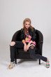 Young Woman in Ripped Jeans Sitting in Chair Young Woman in Ripped Jeans Sitting in Chair