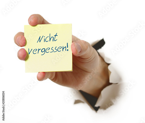 Foto: Hand mit Haftnotiz durchbricht Wand Hand mit Haftnotiz durchbricht Wand