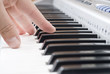 hand playing music on the piano
