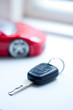 Car key near small remote red super car, vertical