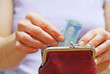 Frau nimmt 20 Euro aus Geldbörse Frau nimmt 20 Euro aus Geldbörse