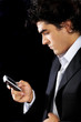 Photo: Business man sending a text message Business man sending a text message