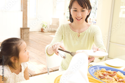 Foto: 食事を取り分ける母親 食事を取り分ける母親