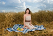 Beautiful slavonic girl on picnic in wheat field