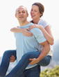 Young man carrying his girlfriend on back - Outdoors