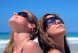 Two Sexy Young Women Sunbathing on a Sandy Beach