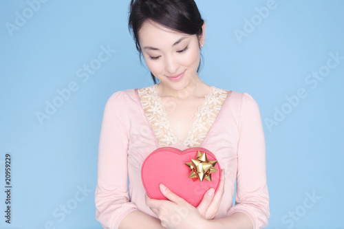 Photo: ハート形のプレゼントを持った女性 ハート形のプレゼントを持った女性