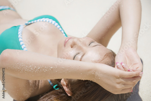 Photo: 砂浜で寝転がる水着女性 砂浜で寝転がる水着女性