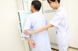 レントゲンをとる患者の腕を支える女性技師