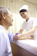 患者の腕をまくる看護師
