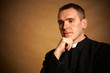 Foto: Priest with hand under chin Priest with hand under chin