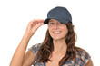 Junge freundliche Frau mit Basecap blickt keck Junge freundliche Frau mit Basecap blickt keck