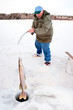 Fisherman Pulling a Big Pike From Under the Ice