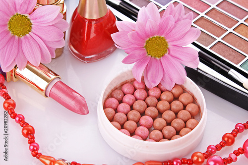 Photo: Many colourful woman cosmetics with flower on white white back Many colourful woman cosmetics with flower on white white back