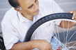 Happy man working on the tyre of his bicycle