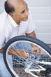 Happy middle aged man repairing a bicycle tyre