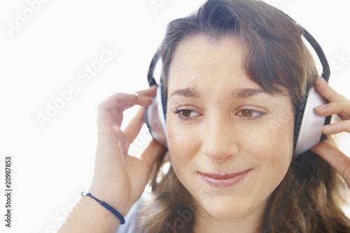 Photo: Closeup of a teenage girl listening to music on headphones Closeup of a teenage girl listening to music on headphones